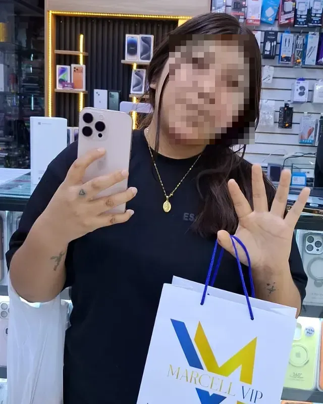 Cliente saludando con su nuevo iPhone y la bolsa de MARCELL VIP